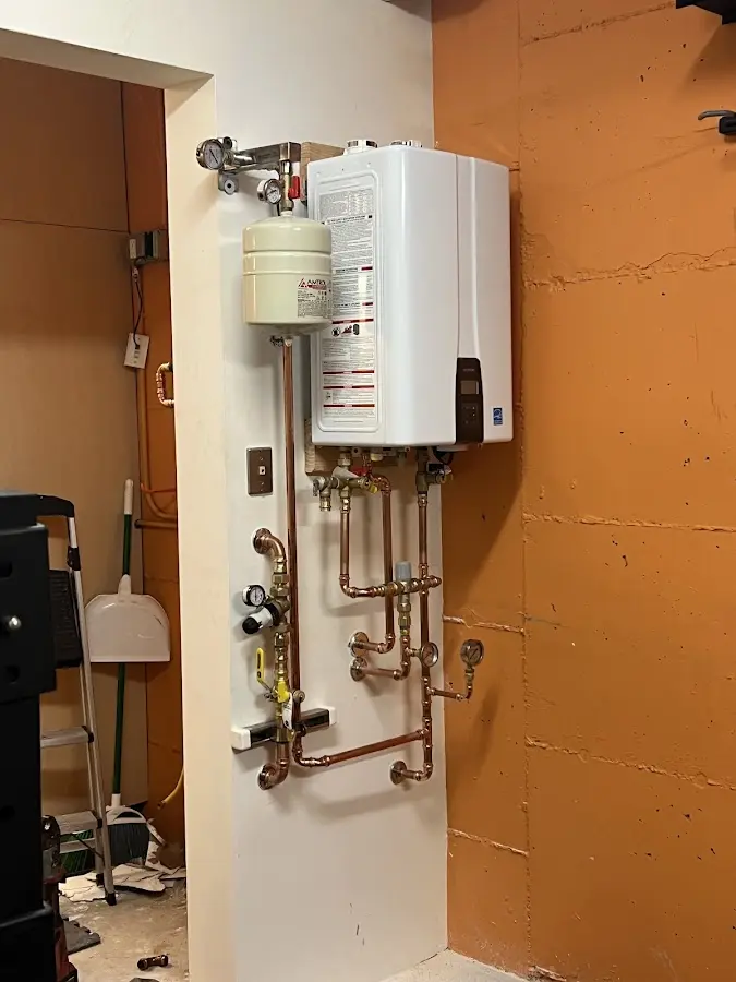 Plumbing technician inspecting water heater connections in Hartford